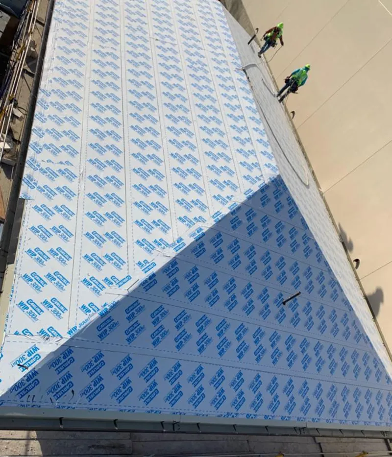 Professional roofers installing underlayment on a metal roof in Port Isabel